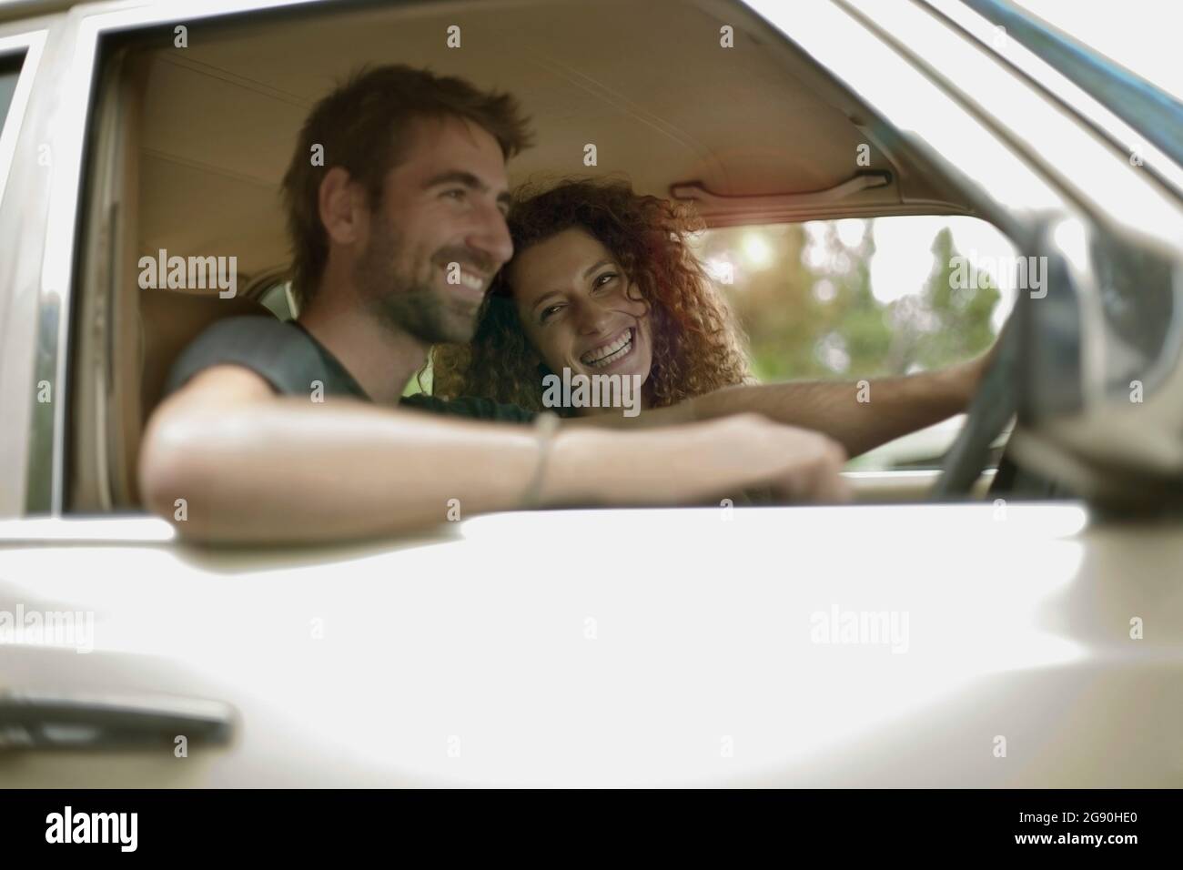 Glückliches junges Paar im Auto unterwegs während der Reise Stockfoto