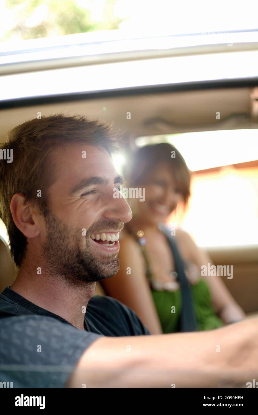 Glücklicher junger Mann mit Freundin im Auto während der Reise Stockfoto