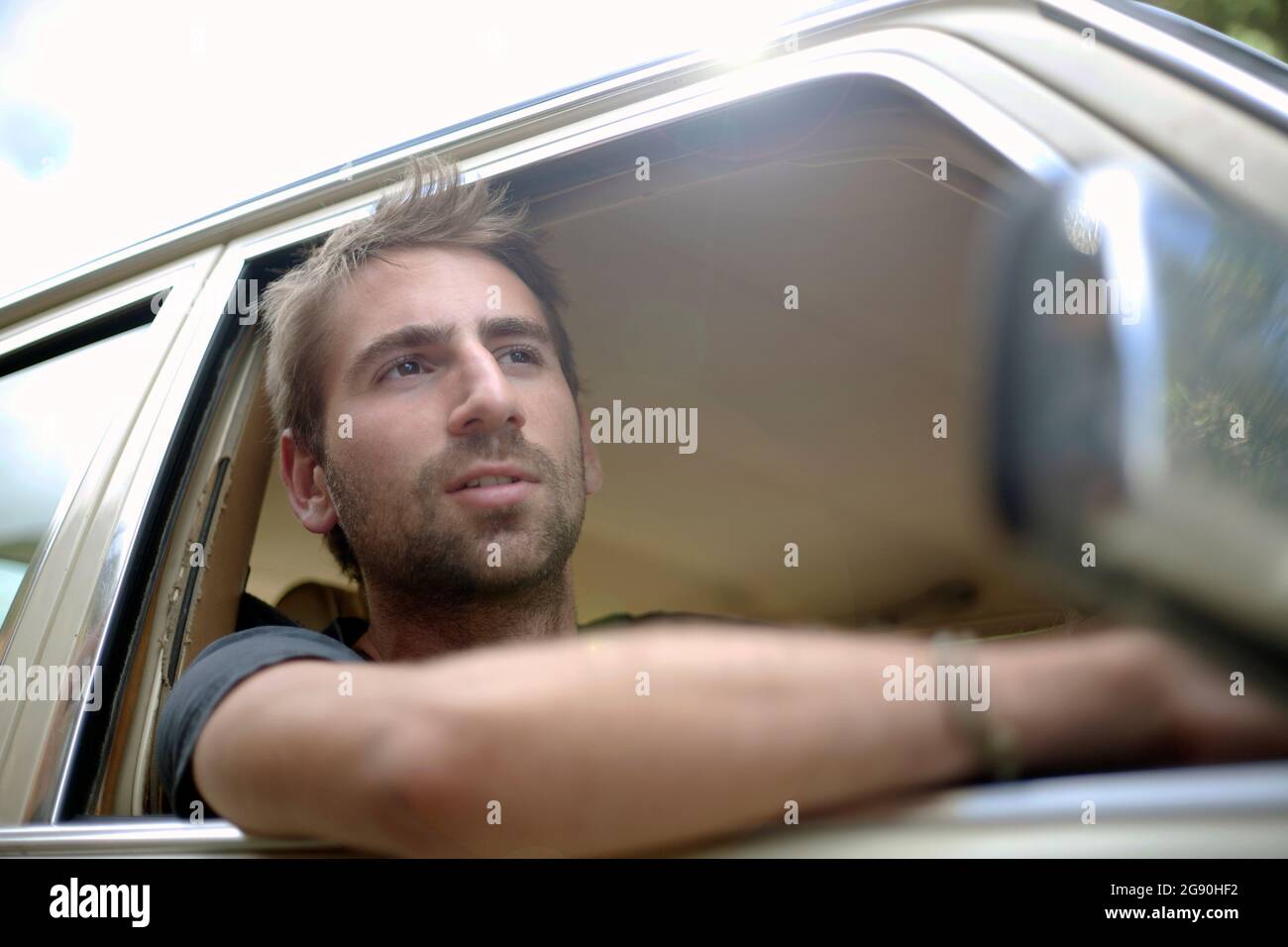 Junger Mann, der durch das Fenster schaute, während er mit dem Auto fuhr Stockfoto