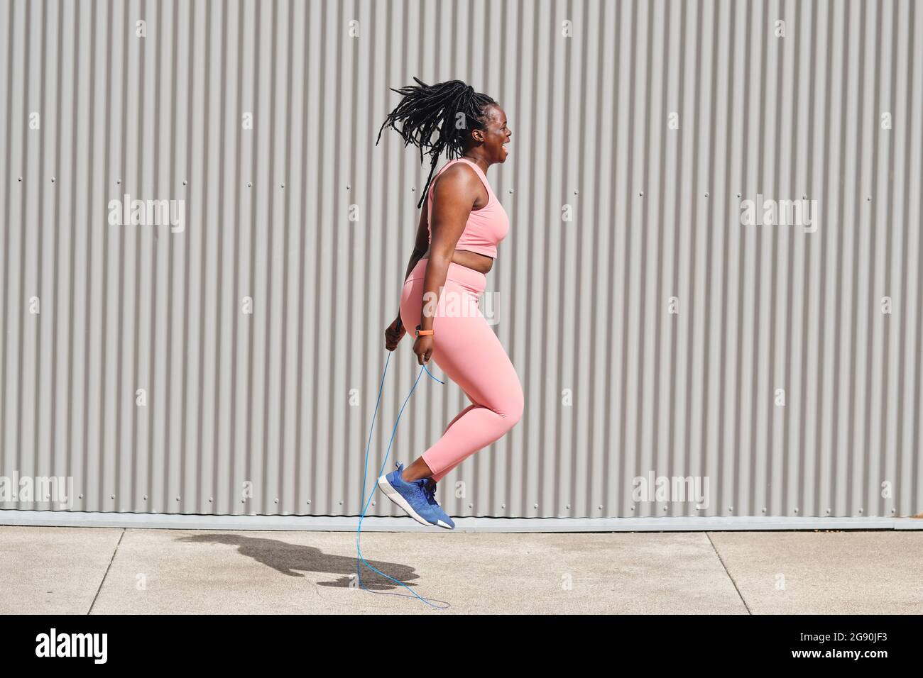Plus Größe Frau hüpft über Fußpfad an sonnigen Tag Stockfoto