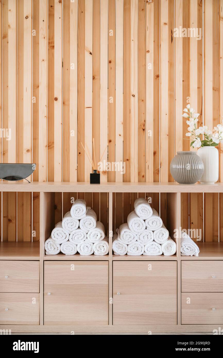 Holzgestell mit zusammengerollten Handtüchern im Pilates-Studio gestapelt Stockfoto