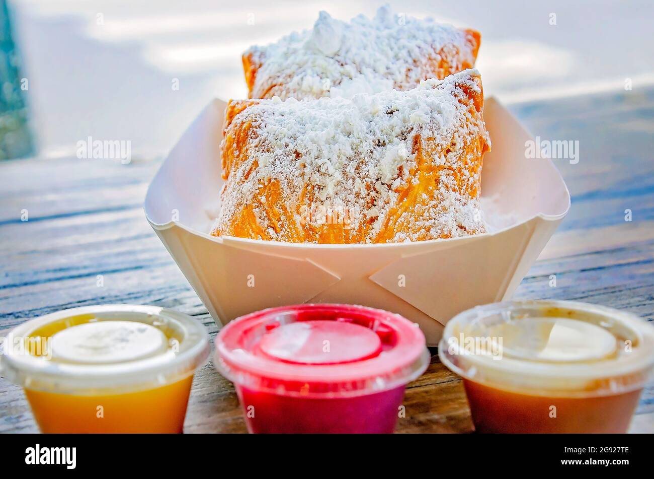 Beignets werden in Mo’ Bay Beignet Co., 23. Juli 2021, in Mobile, Alabama, mit Buttercreme, Himbeere und Zimt-Dipping-Sirup serviert. Stockfoto