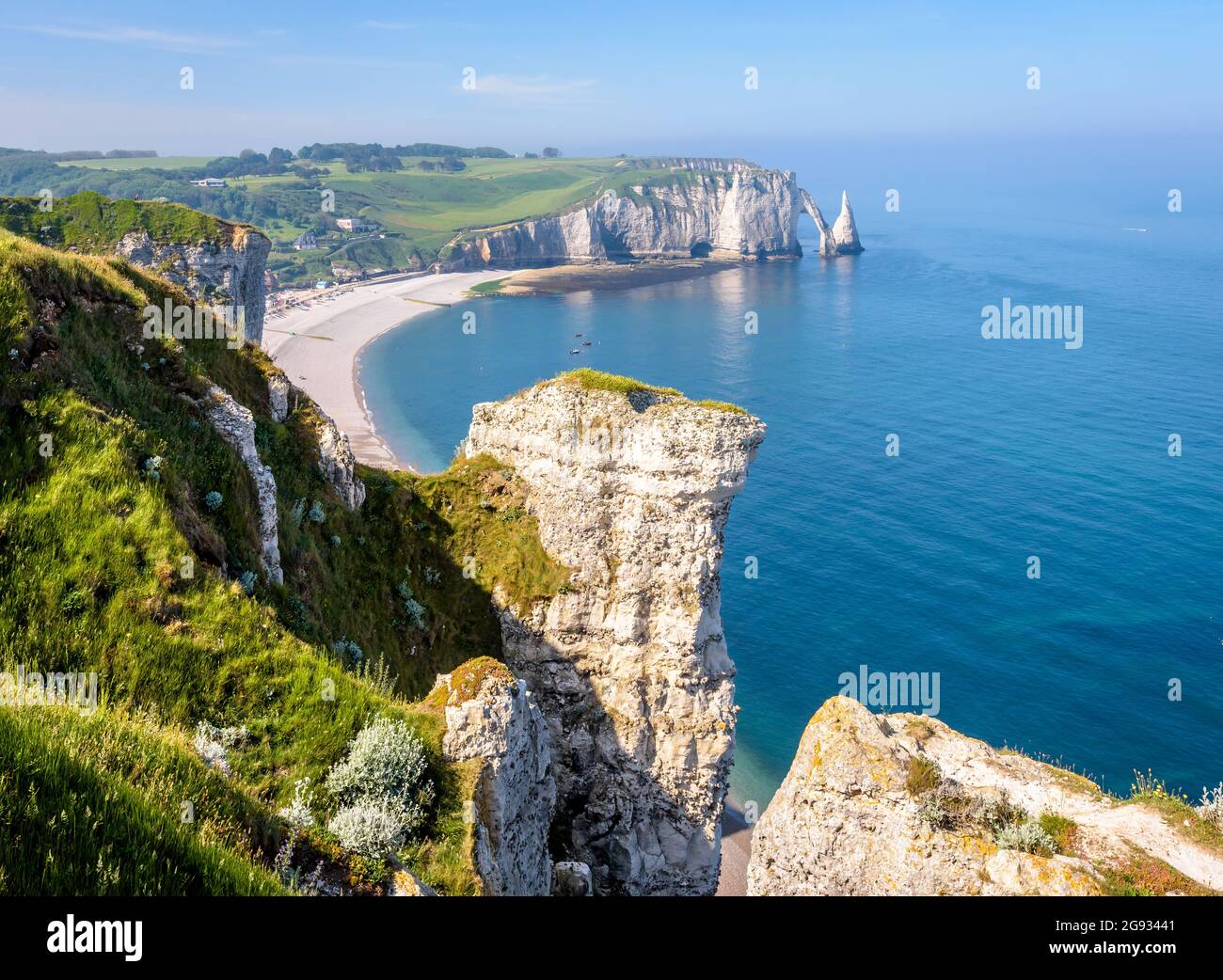 Der Strand und die Aval-Klippe in Etretat, Normandie, mit dem Bogen und der Nadel von der Amont-Klippe aus gesehen, mit Kreidepitonen im Vordergrund. Stockfoto