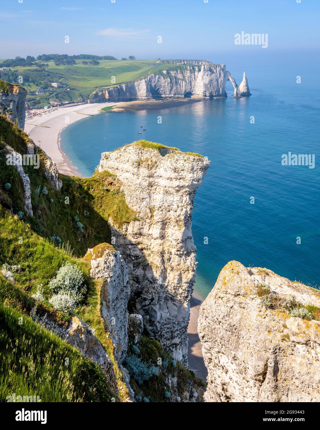 Der Strand und die Aval-Klippe in Etretat, Normandie, mit dem Bogen und der Nadel von der Amont-Klippe aus gesehen, mit Kreidepitonen im Vordergrund. Stockfoto