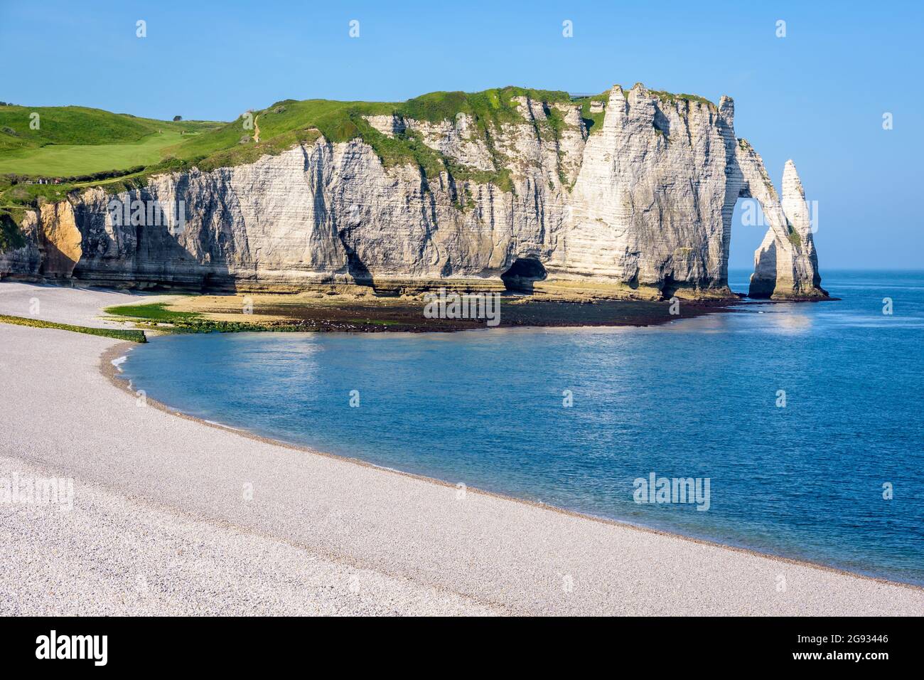Nahaufnahme der Aval-Klippe mit dem Bogen und der Nadel vom Kiesstrand von Etretat in der Normandie an einem sonnigen Frühlingsmorgen. Stockfoto