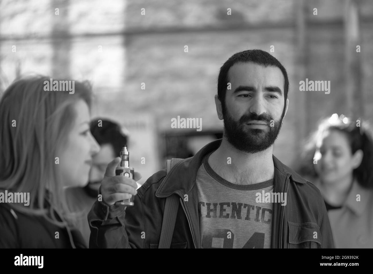 ISTANBUL, TÜRKEI - 07. März 2020: Eine Graustufenaufnahme einer Gruppe türkischer Menschen, die in der Taksim Street, Istanbul, sprechen Stockfoto