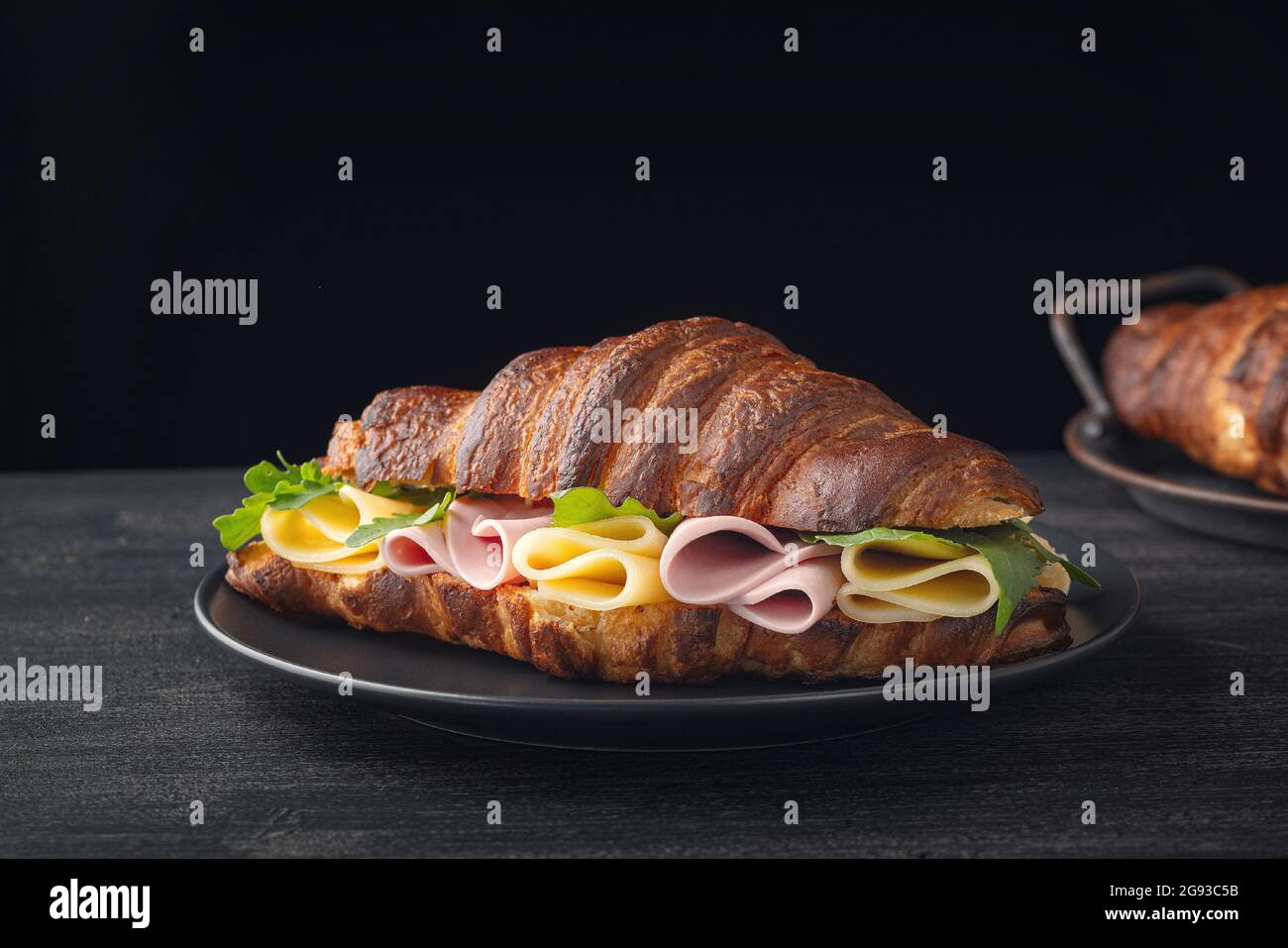 Croissant-Sandwich auf Holztisch Stockfoto