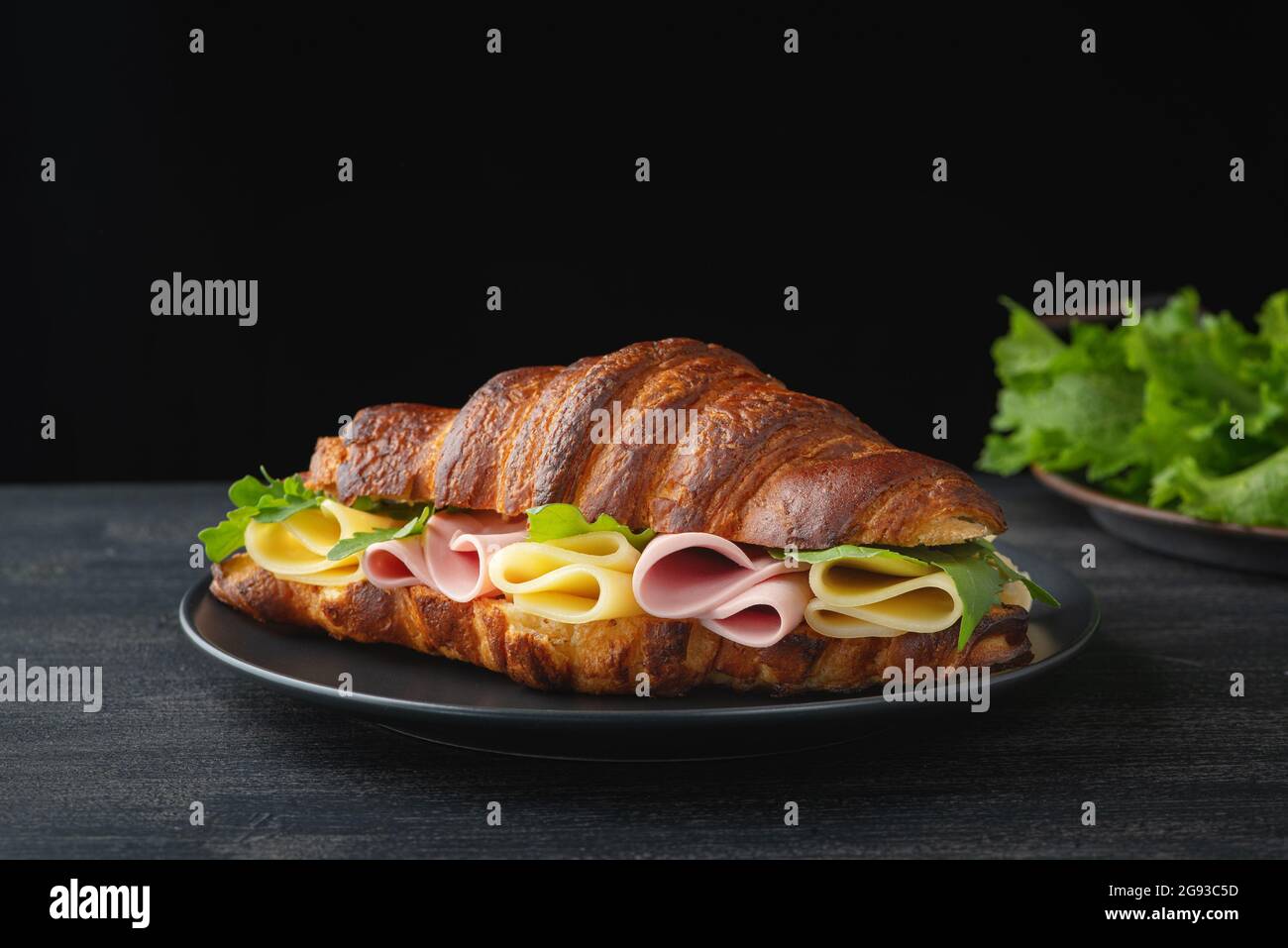 Croissant-Sandwich auf Holztisch Stockfoto