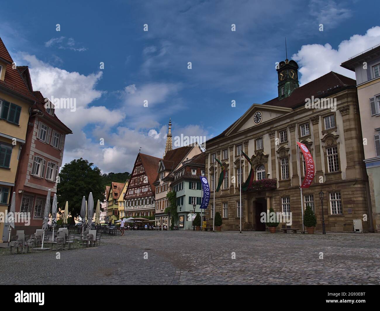 Historischer Rathausplatz mit Kopfsteinpflaster und alten Gebäuden am bewölkten Sommertag. Stockfoto