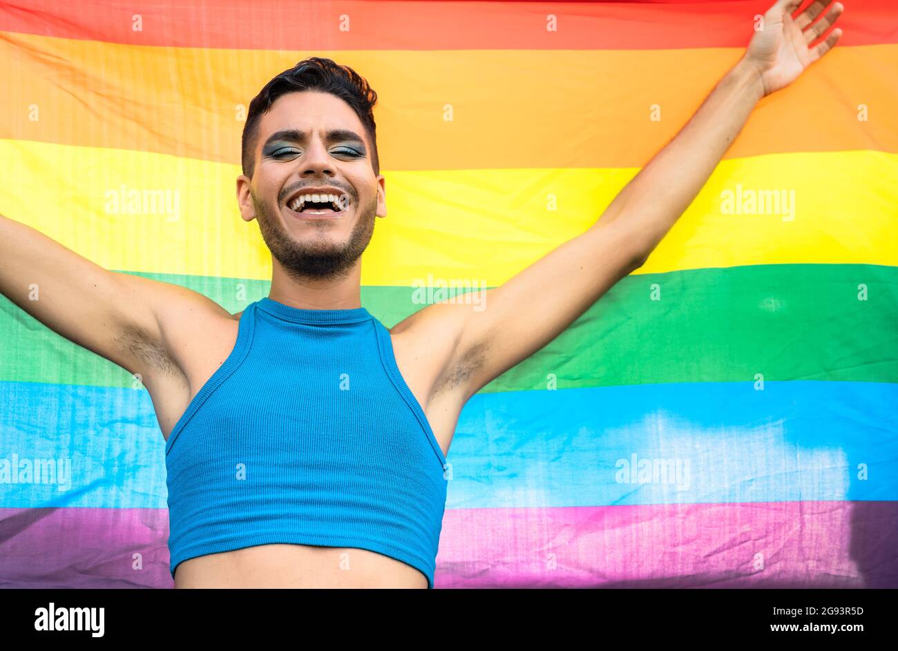 Glücklicher homosexueller Mann feiert Homosexuell Stolz mit Regenbogenflagge Symbol der LGBTQ Gemeinschaft Stockfoto