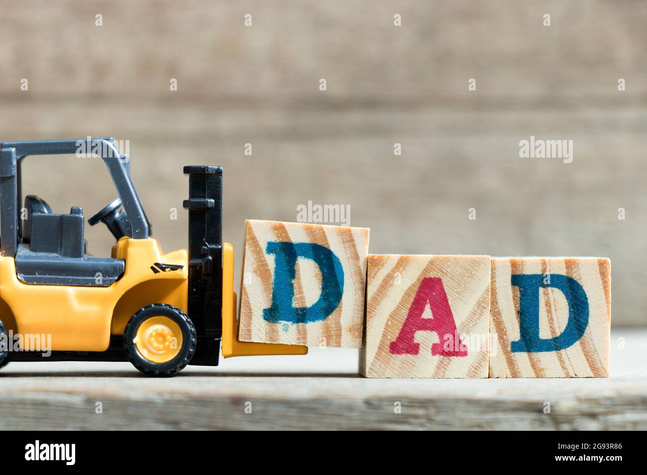 Spielzeug gelb Gabelstapler halten schreiben Block D zu Wort Vati auf Holz Hintergrund komplett (Konzept der Vater Tag) Stockfoto