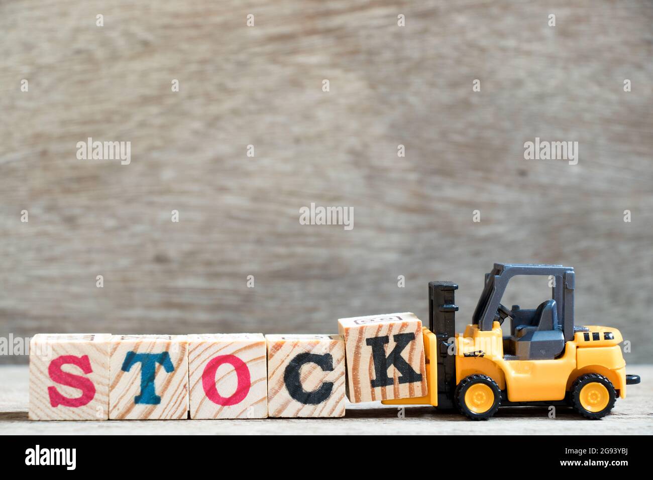 Spielzeug Gabelstapler halten schreiben Block K zu Wort bestand auf Holz Hintergrund abgeschlossen Stockfoto