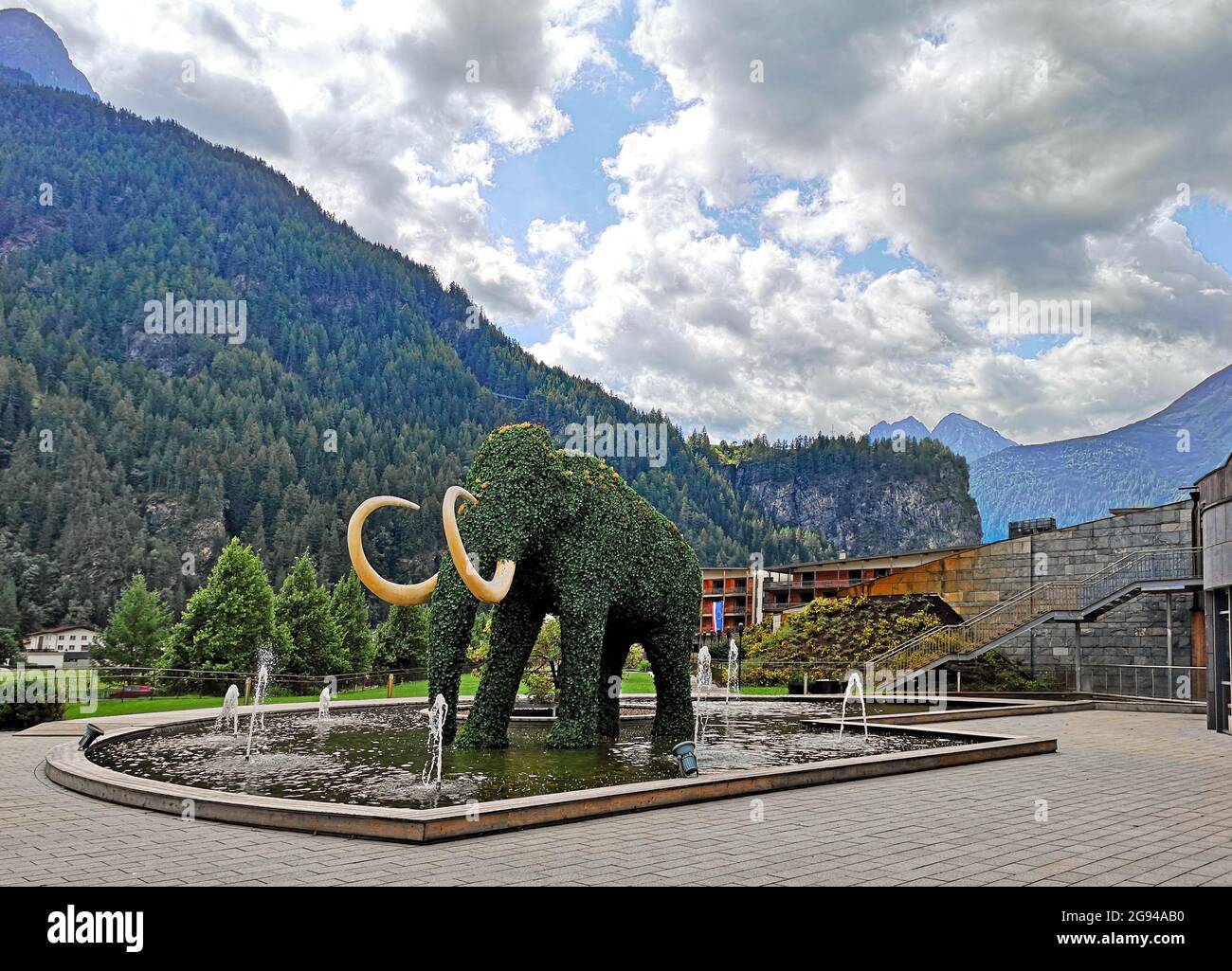 Urbane und naturalistische Landschaft in Österreich in der Stadt Wattens, Springbrunnen mit Elefantenhecke im Zentrum Stockfoto