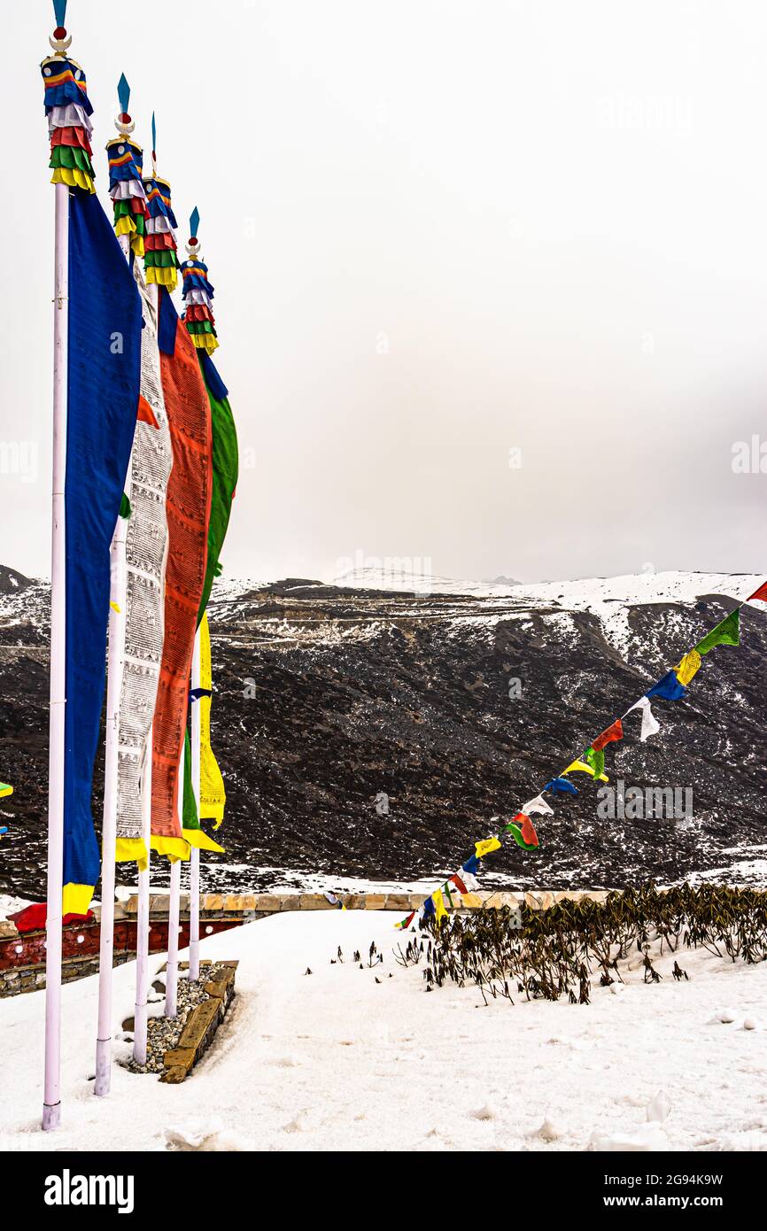 die heilige buddhistische Flagge am Kriegsdenkmal mit schneebedeckten Bergen im Hintergrundbild wurde am jaswant singh Kriegsdenkmal Bumla Pass arunachal pradesh aufgenommen Stockfoto