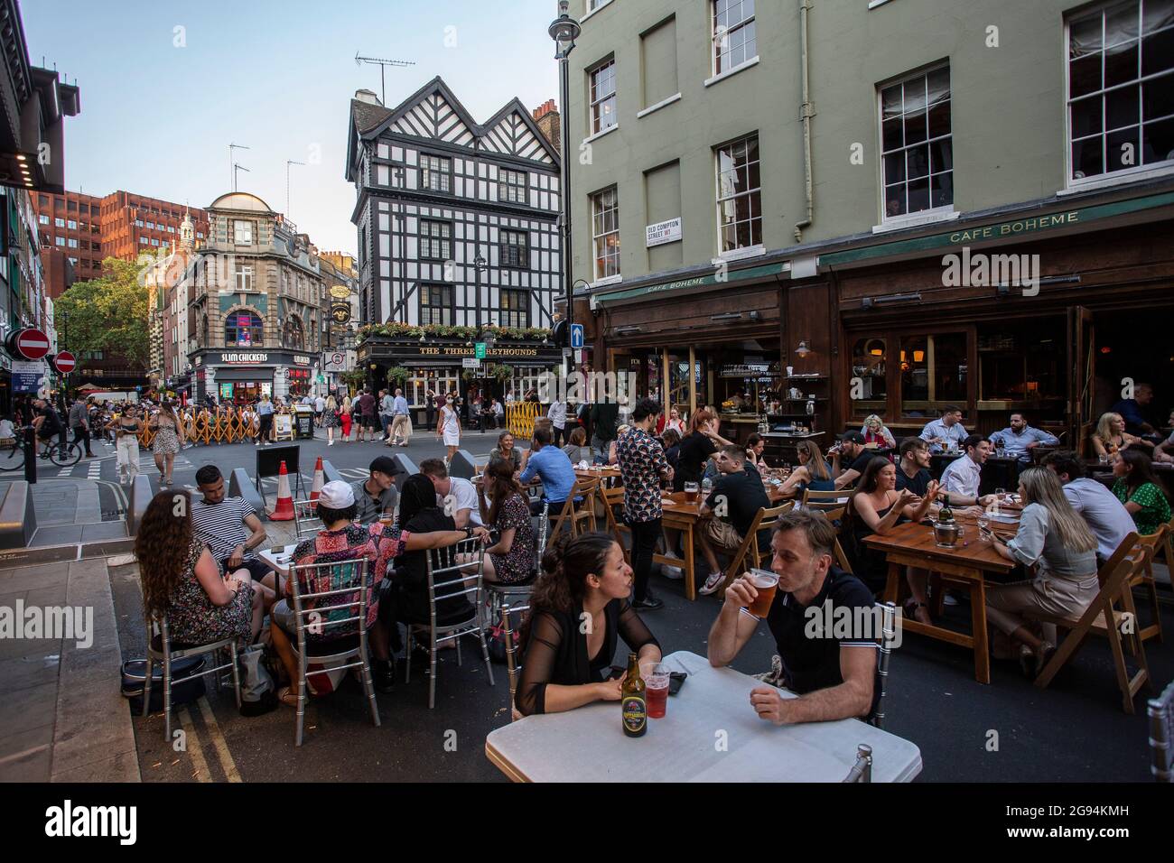 Menschen, die im Zentrum Londons im Freien essen und trinken, werden in der Old Compton Street, Soho, London, Großbritannien die Einschränkungen von Covid aufgehoben. Stockfoto