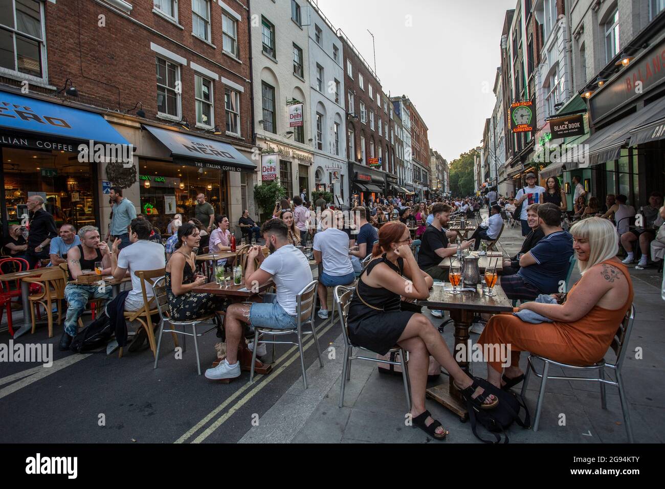 Menschen, die auf Tischen auf der Frith Street in Soho, London, am 23. Juli 2021, trinken Stockfoto