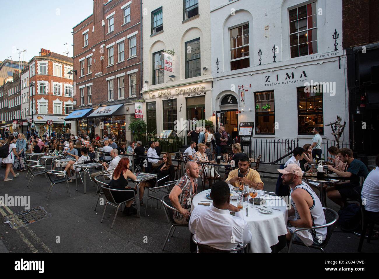 Menschen, die auf Tischen auf der Frith Street in Soho, London, am 23. Juli 2021, trinken Stockfoto