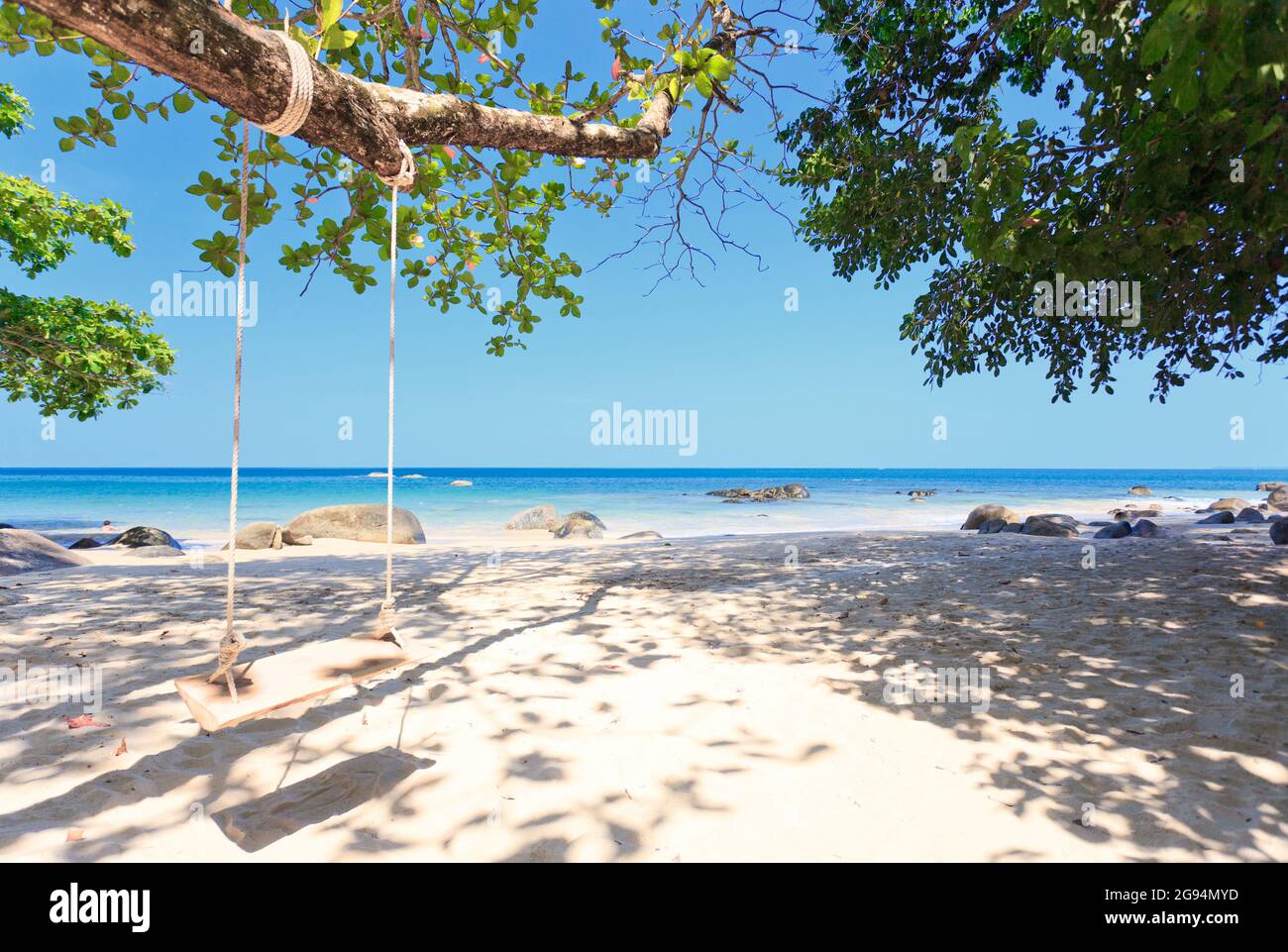 Holz schwingen unter Baum am Strand in blauem Himmel Stockfoto