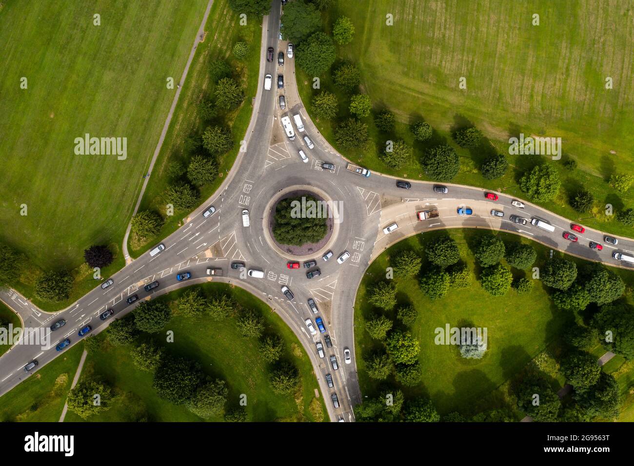 Luftaufnahme eines geschäftigen Kreisels auf der Landstraße zur Hauptverkehrszeit mit anwartendem Verkehr Stockfoto