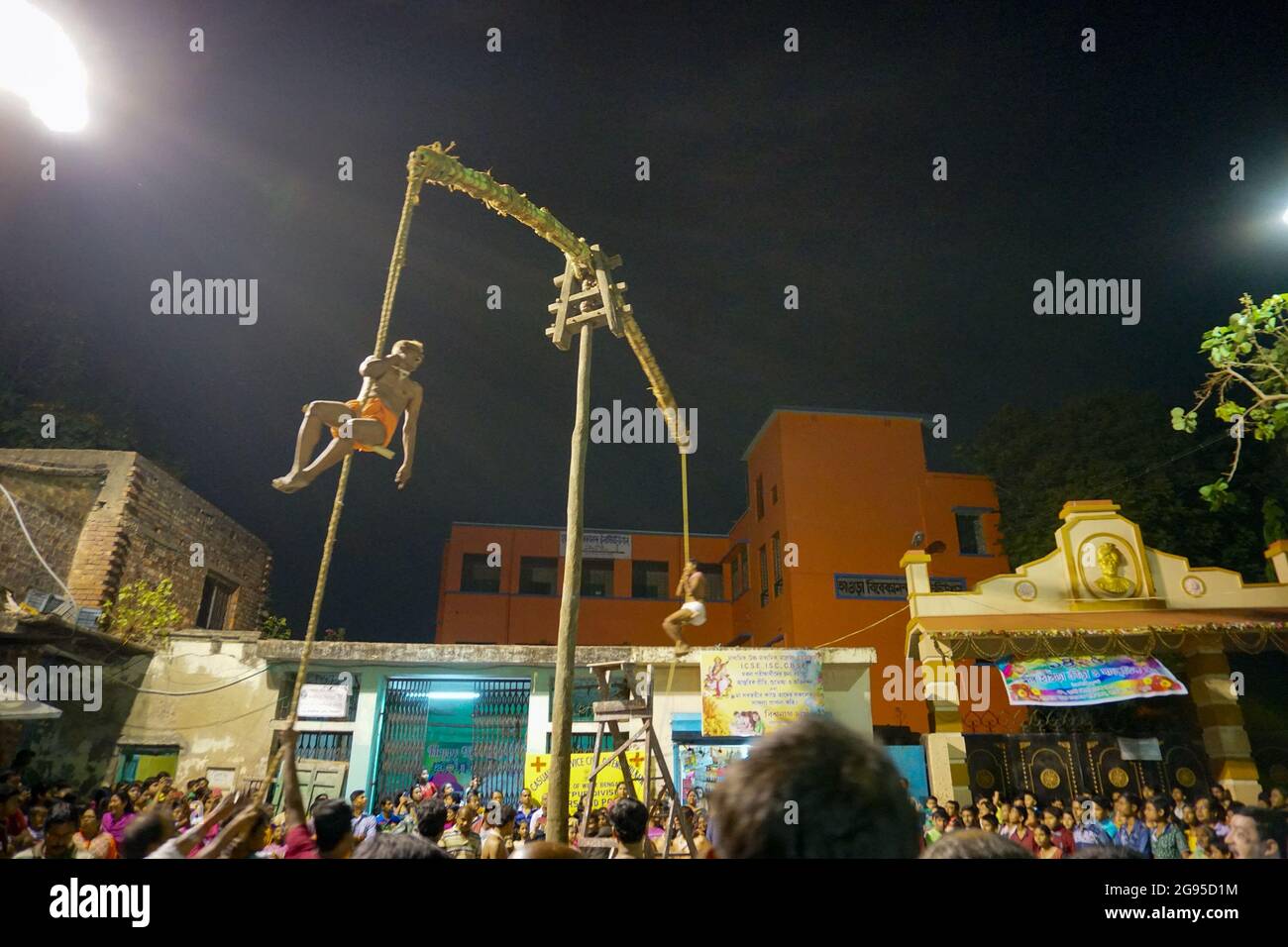 KOLKATA, WESTBENGALEN, INDIEN - 15. APRIL 2018: Zwei hinduistische Anhänger hängen nachts an der Stange in der Luft. Religiöse Sportarten für das Fest genannt Charhak o Stockfoto