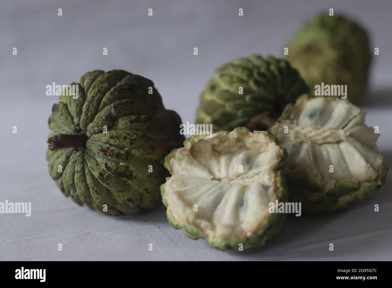 Cherimoya ist eine grüne, kegelförmige Frucht mit ledriger Haut und cremigem, süßem Fruchtfleisch. Es ist auch als Puddingapfel bekannt. Die Früchte variieren in Form, Herz Stockfoto