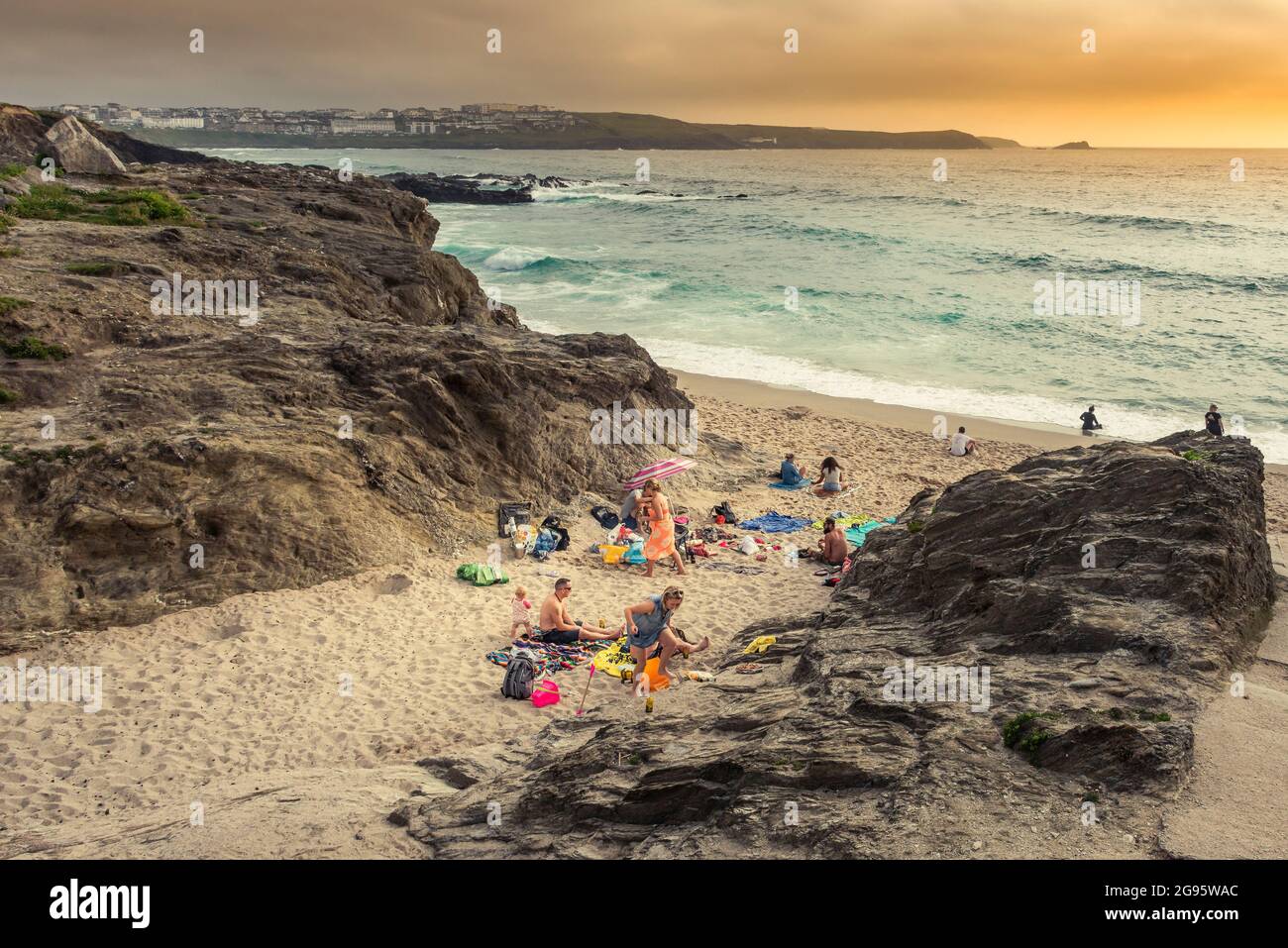Urlauber genießen die späte Abendsonne am abgelegenen Strand von Little Fistral in Newquay in Cornwall. Stockfoto