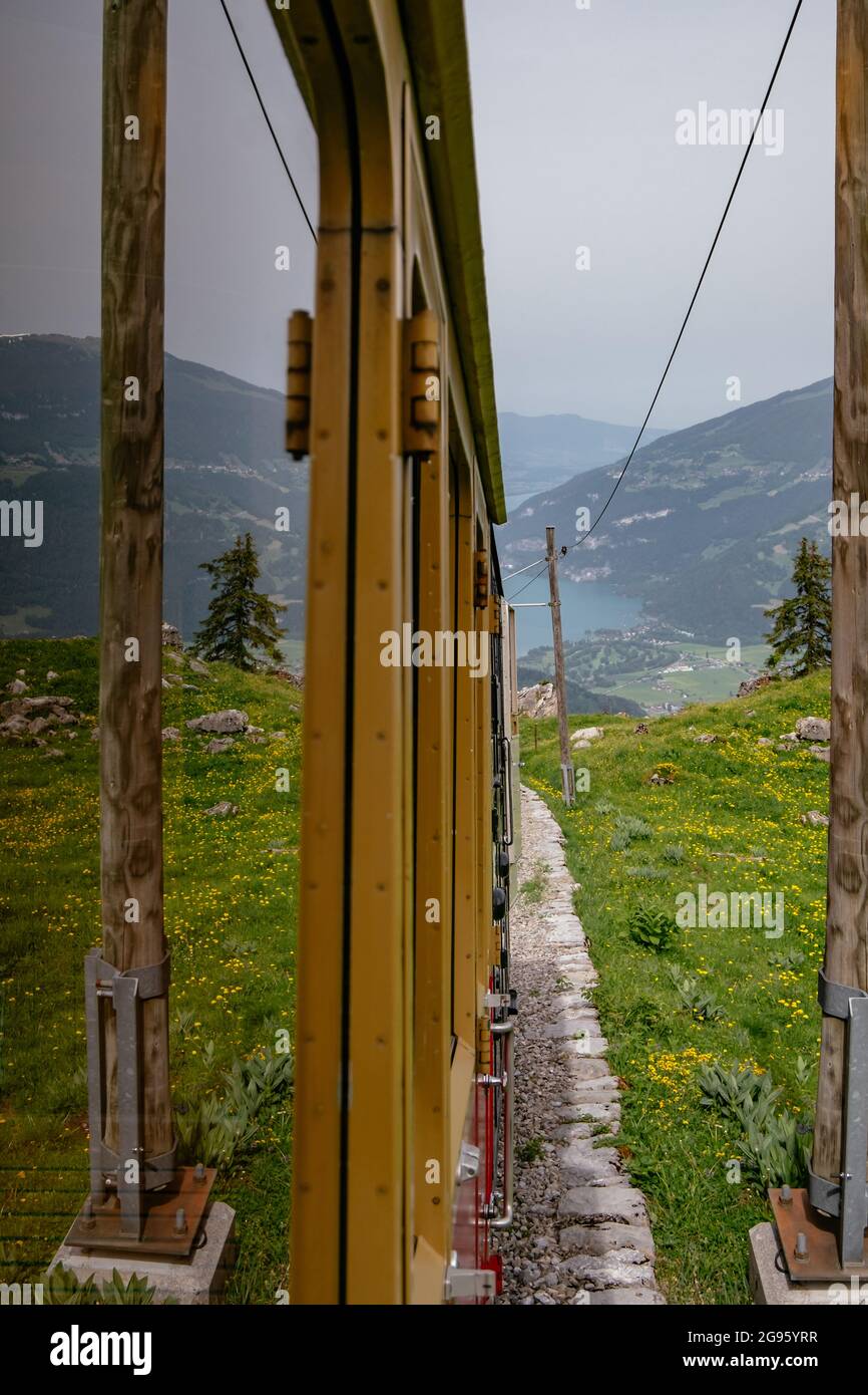 Schynige Platte, Berner Oberland, Schweiz - Touristischer Zahnradwagen mit rotem Zug in atemberaubendem Panorama mit Schweizer Alpen und Brienzersee Stockfoto