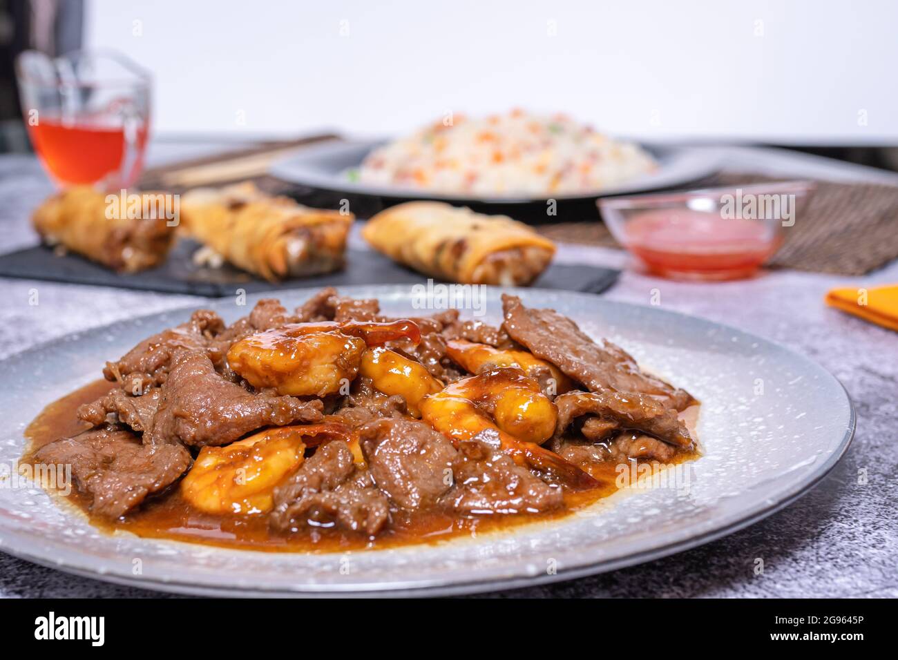 Chinesische Speiseteller, Rindfleisch in Sauce mit Bambus und chinesischen  Pilzen, s-saure Sauce, Reis 3 Kstlichkeiten und Frhlingsrollen.  Asiatische Kche Stockfotografie - Alamy