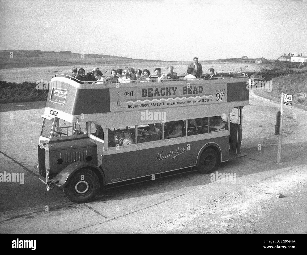 50er Jahre, historisch, 'Visit Beachy Head'....Menschen in einem Doppeldeckerbus mit offenem Oberdeck, einem Versorgungsunternehmen Guy Arab', Service 97, geparkt an Beachy Head, einer Landzunge auf den South Downs in Eastbourne, East Sussex. Die höchsten kalkförmigen Klippen Großbritanniens mit ihren hügeligen Abfahrten sind ein berühmter Ort für Spaziergänge mit Blick auf den Ärmelkanal. Ein Gebiet von außergewöhnlicher natürlicher Schönheit, im Jahr 1929 wurde das Land gekauft, um seine Nutzung für zukünftige Generationen zu sichern. Southdown Motors betreibt die Route 97 von der Royal Parade bis zum Gipfel des Beachy Head, einem Service für Tagesausflügler, der aus dem 1. Weltkrieg stammt. Stockfoto
