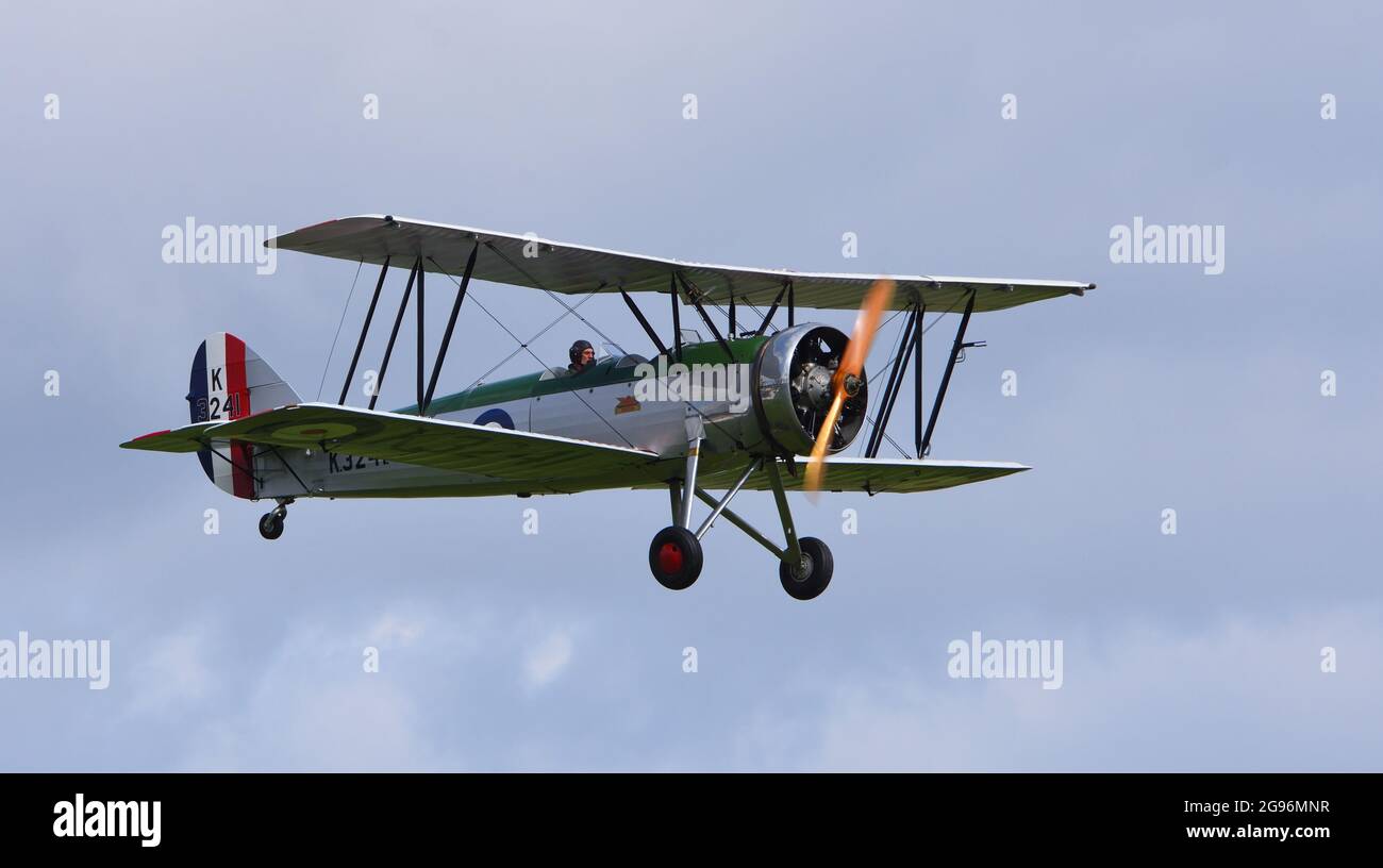 Vintage Avro 621 Tutor Doppeldecker-Flugzeug im Flug wolkigen Himmel. Stockfoto