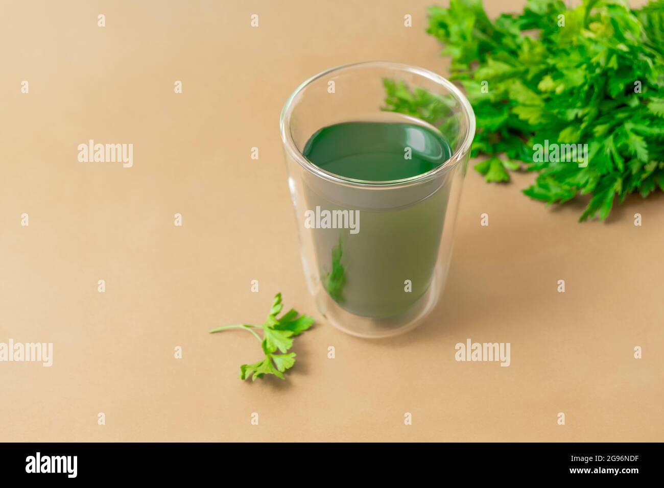 Tasse Chlorophyllwasser auf hellbeigem Hintergrund mit Kopierraum Stockfoto