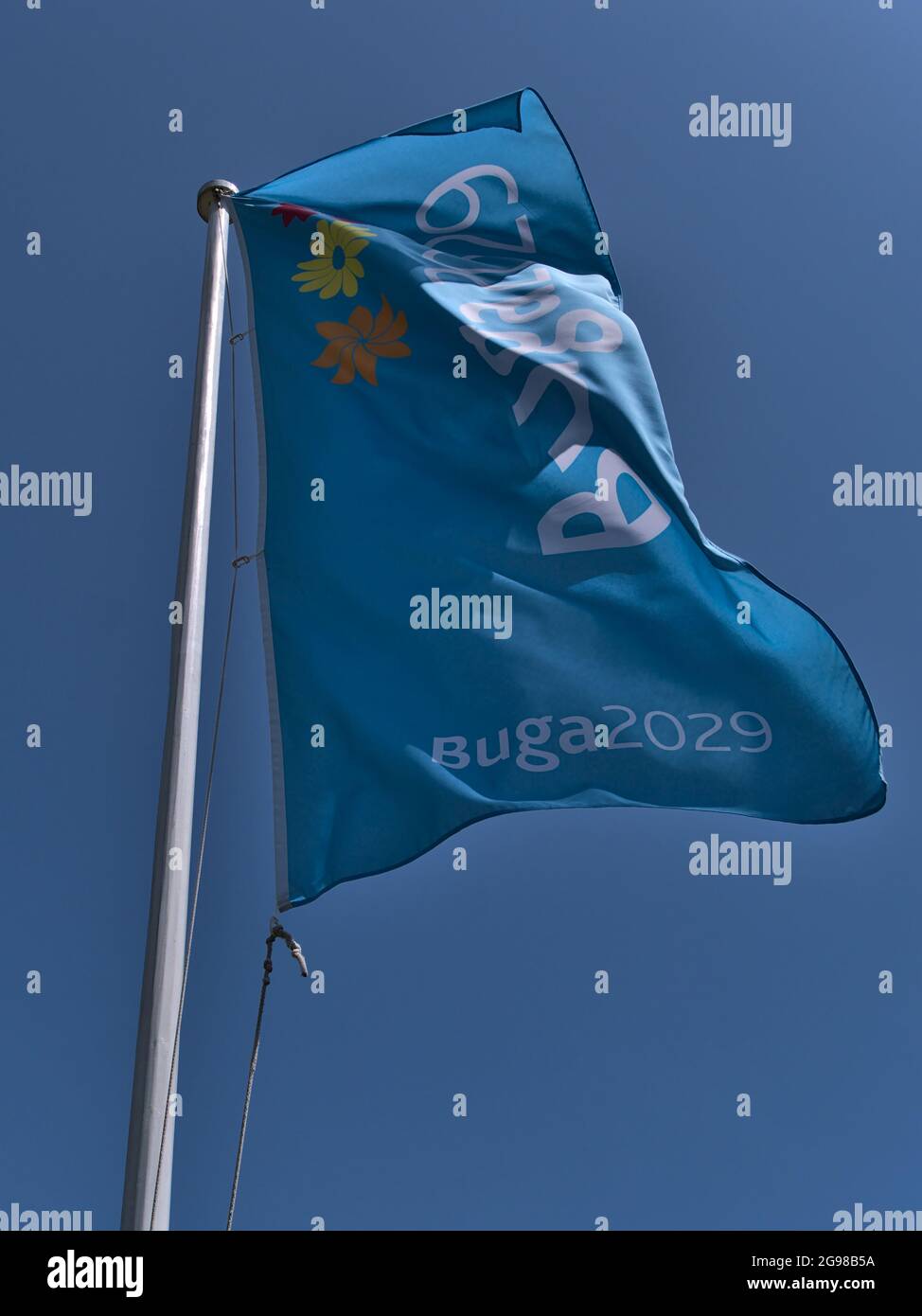 Flachwinkelansicht des Fahnenmastes mit hellblauer Flagge für die Bundesgartenschau (BUGA) 2029, eine alle zwei Jahre stattfindende Gartenbaumesse. Stockfoto