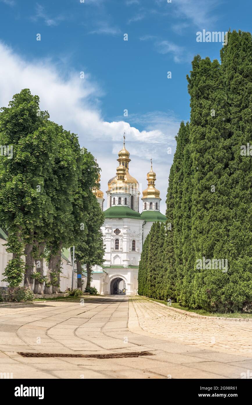 Eine vertikale Aufnahme von Kiev Pechersk Lavra und einem Pfad, der von hohen Bäumen umgeben ist Stockfoto