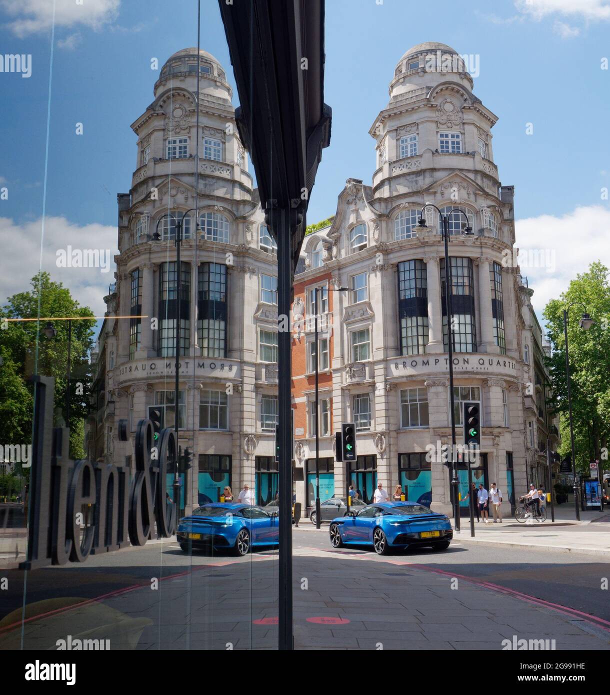 London, Greater London, England, Juni 12 2021: Spiegelbild des Brompton Quarter Empire House und blauer Sportwagen. Stockfoto