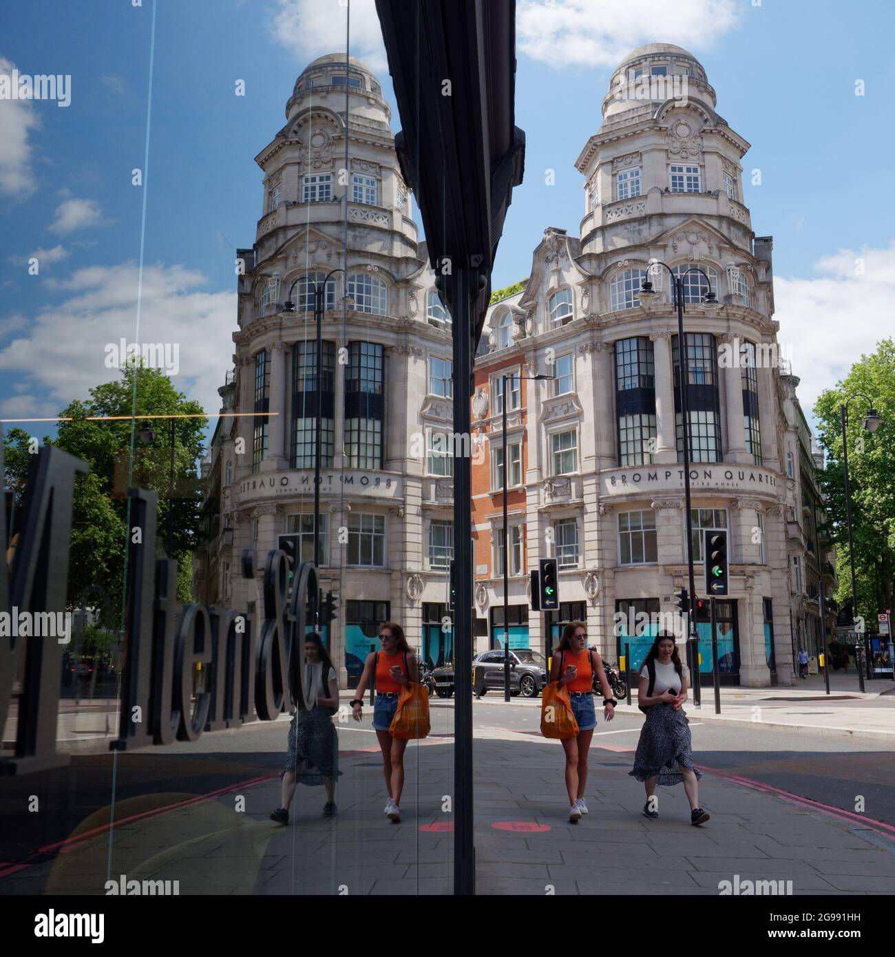 London, Greater London, England, Juni 12 2021: Spiegelbild des Brompton Quarter Empire House mit zwei Frauen im Vordergrund. Stockfoto
