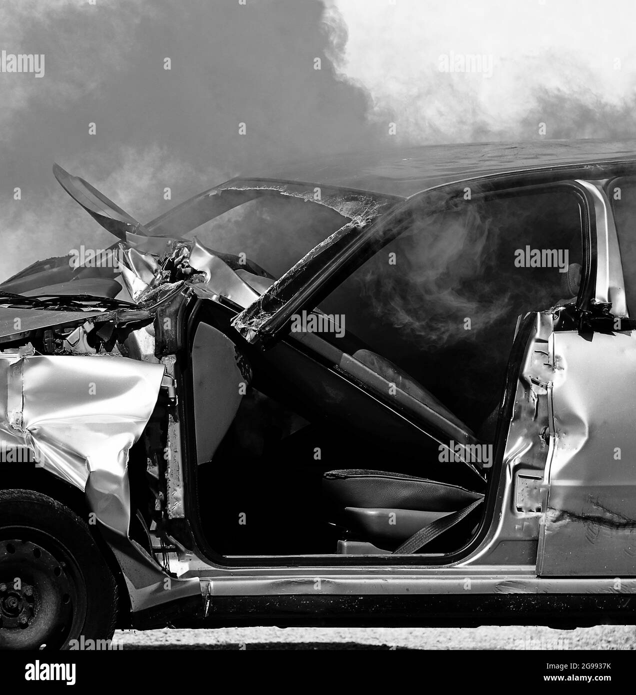 Kaputtes Auto nach dem Unfall und dichter Rauch mit Schwarz-Weiß-Effekt Stockfoto