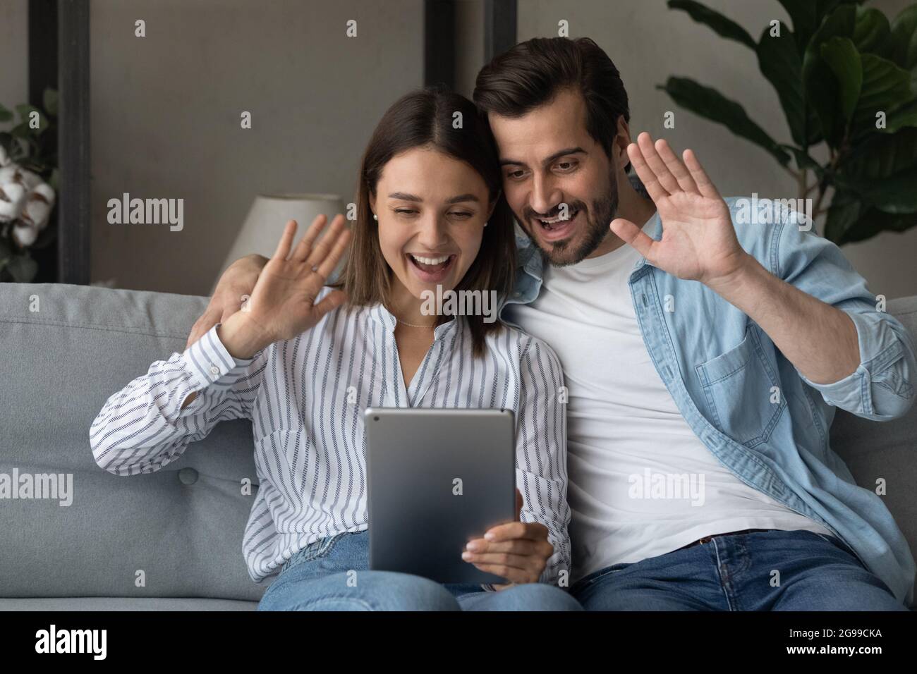 Paar sitzen auf der Couch Verwenden Sie Tablet Starten Sie Talk per Videokonferenz Stockfoto