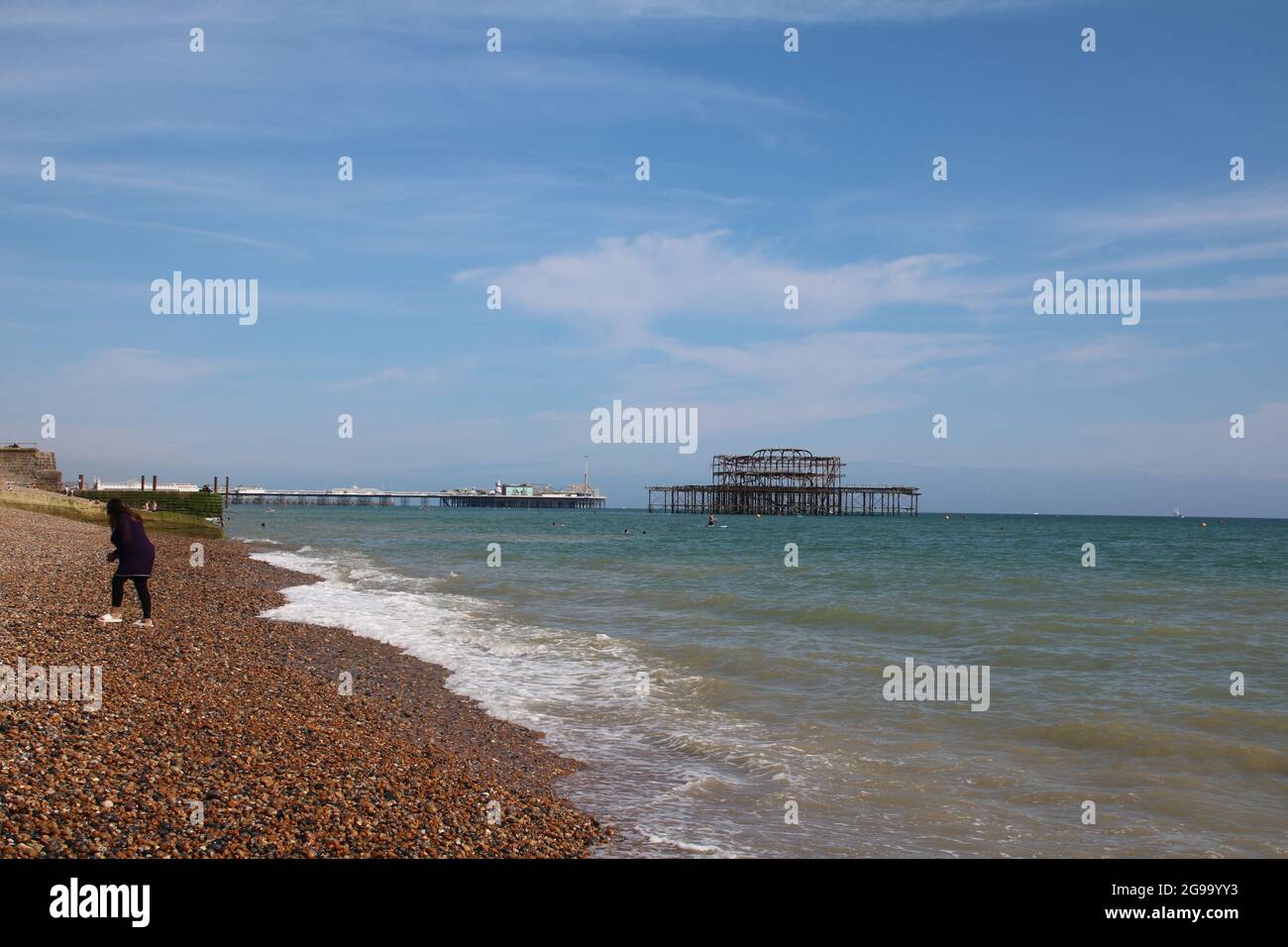 Brighton Piers umgeben von einem ruhigen Meer an einem Sommertag Stockfoto