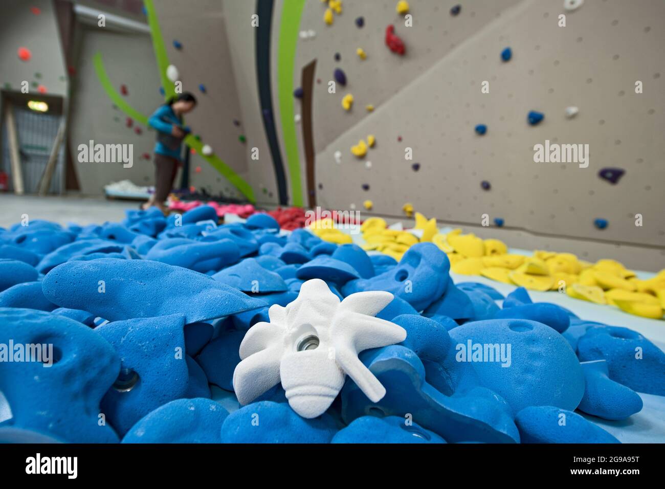 Nahaufnahme der Klettergriffe an der Indoor-Kletterwand Stockfoto