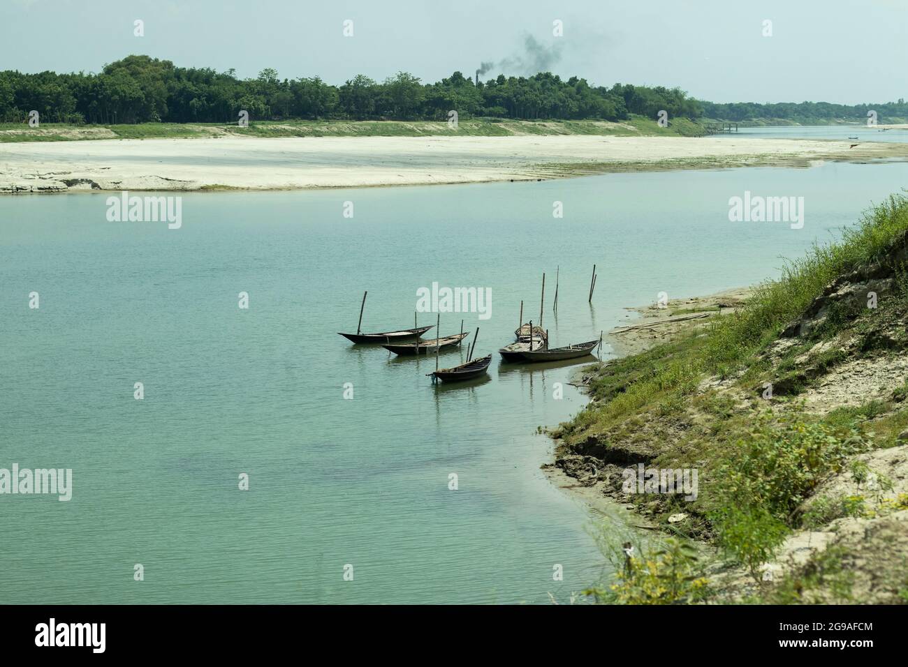 Der kleine Fluss Gorai mit blauem Wasser und einem Boot, das auf dem Wasser schwimmt und von Grün umgeben ist Stockfoto