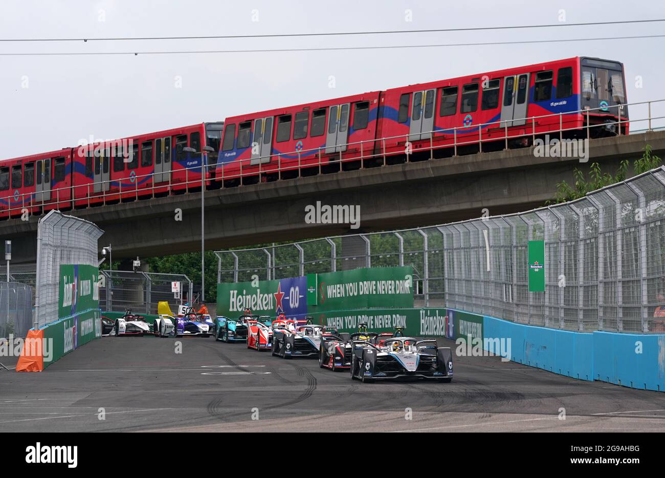 Stoffel Vandoorne vom Mercedes-EQ Formel E Team führt unter einem Sicherheitsfahrzeug an, während ein Zug während des Heineken London E-Prix in Excel London über den Kopf fährt. Bilddatum: Sonntag, 25. Juli 2021. Stockfoto