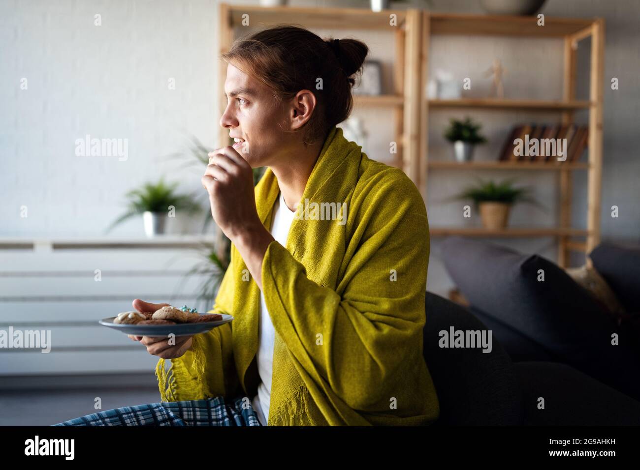 Junger Mann, der sich zu Hause entspannt. Friedliche Erholung zu Hause am Morgen Stockfoto