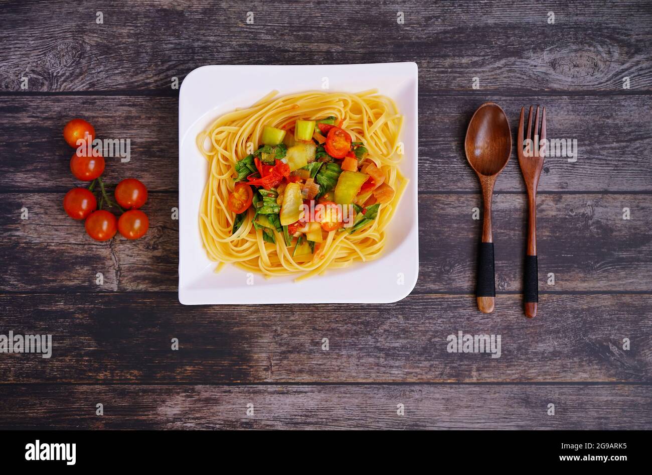 Hausgemachte Linguine-Pasta mit Gemüse auf einem rustikalen Holztisch. Stockfoto