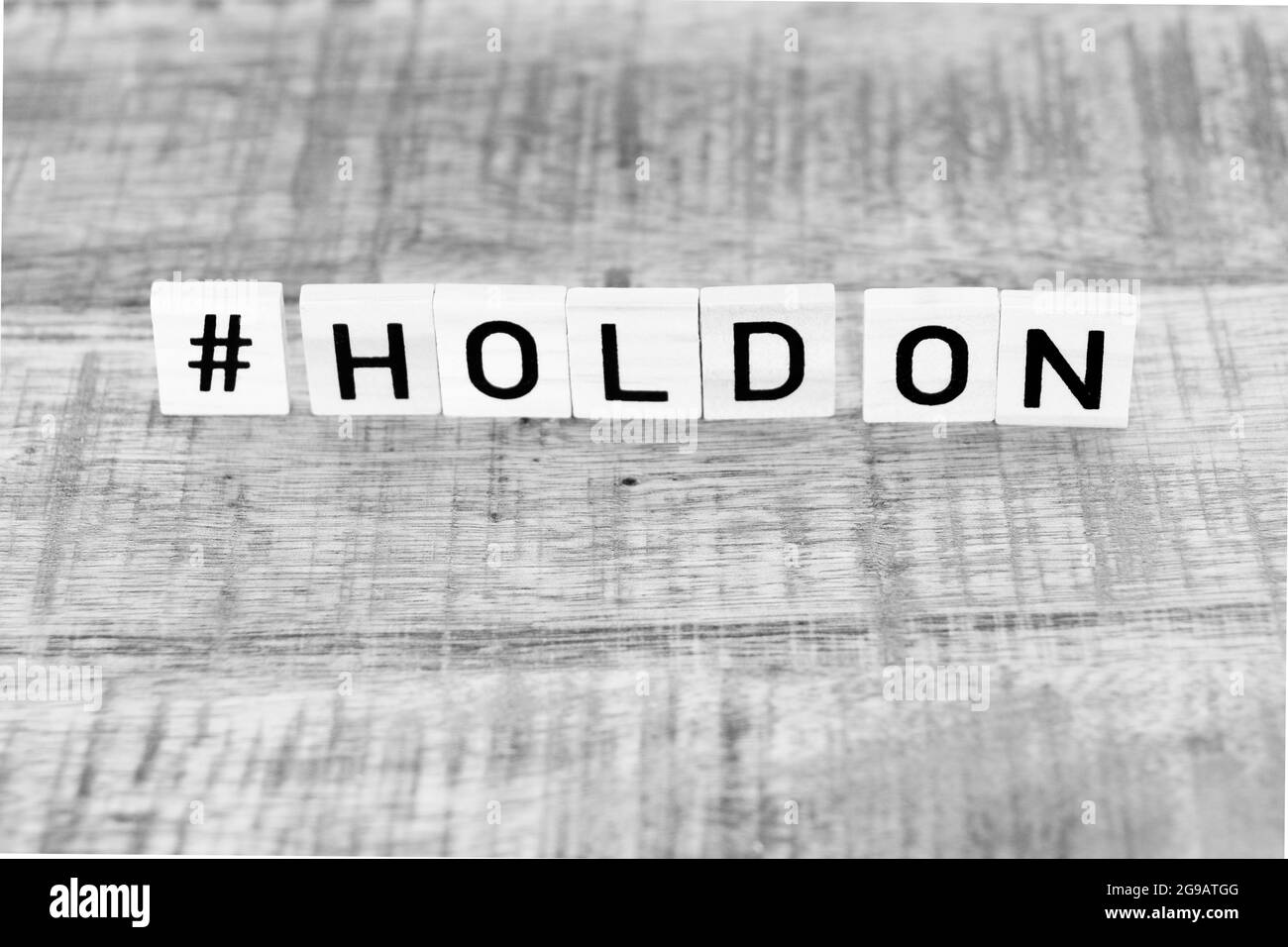 Holzwürfel bilden die Worte #Hold On Stockfoto