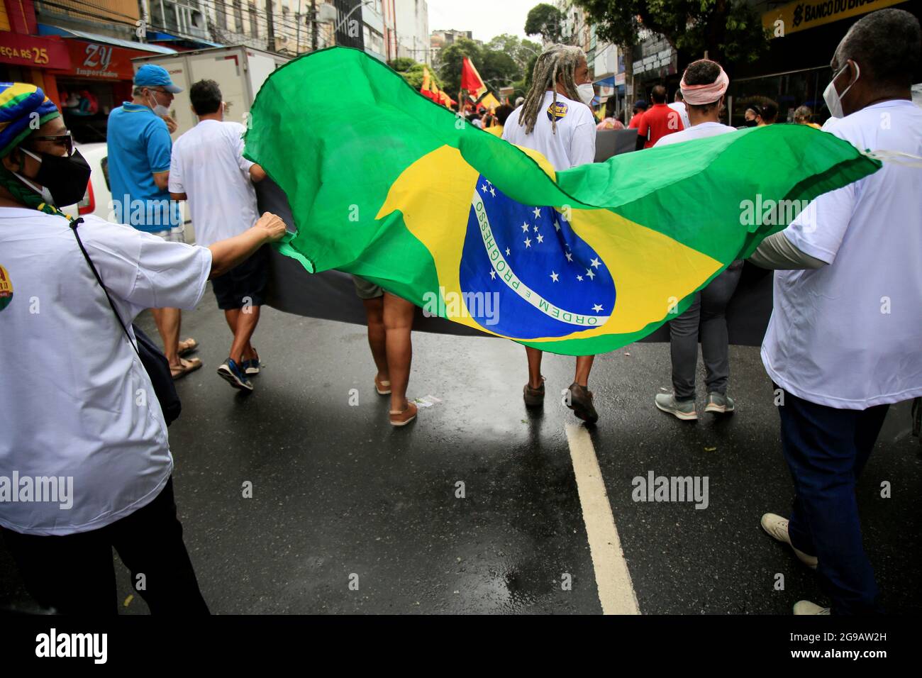 salvador, bahia, brasilien - 24. juli 2018: Protestler trägt die brasilianische Flagge während des Protestes gegen die Regierung von Präsident Jair Bolsonaro in der Stockfoto