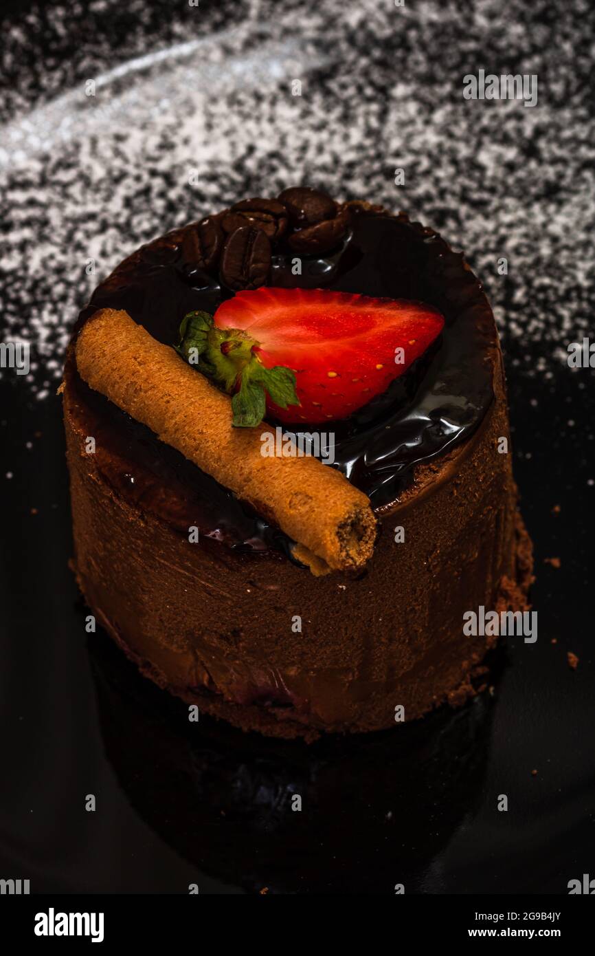 Ein vertikaler Schuss Schokoladenmousse Kuchen mit einer Erdbeere Stockfoto