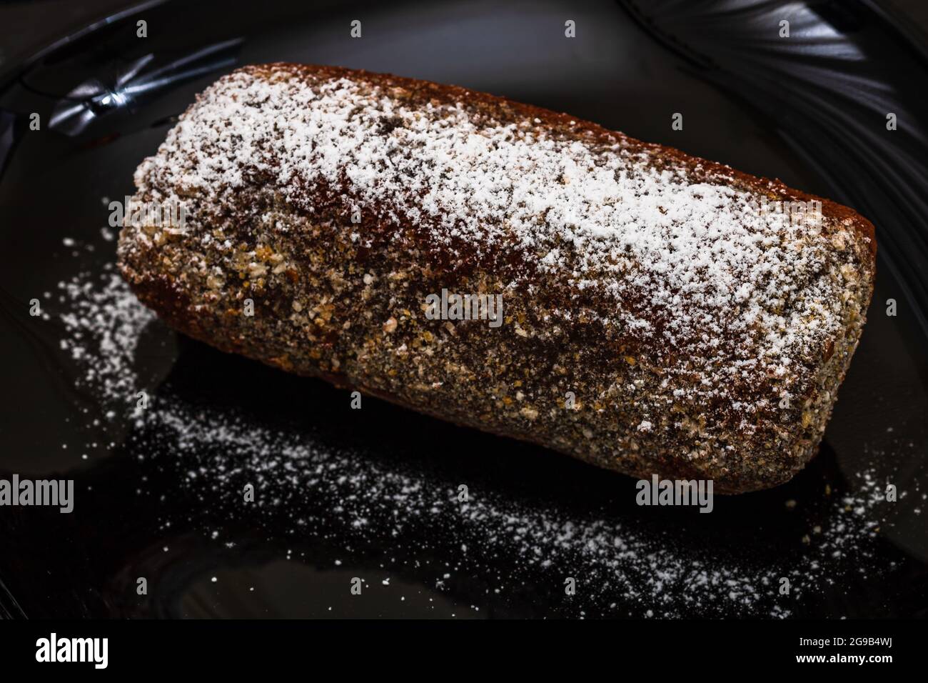 Ein hochgedrehter Schuss eines Schokoladenmousse-Kuchenstückes auf schwarzem Teller Stockfoto