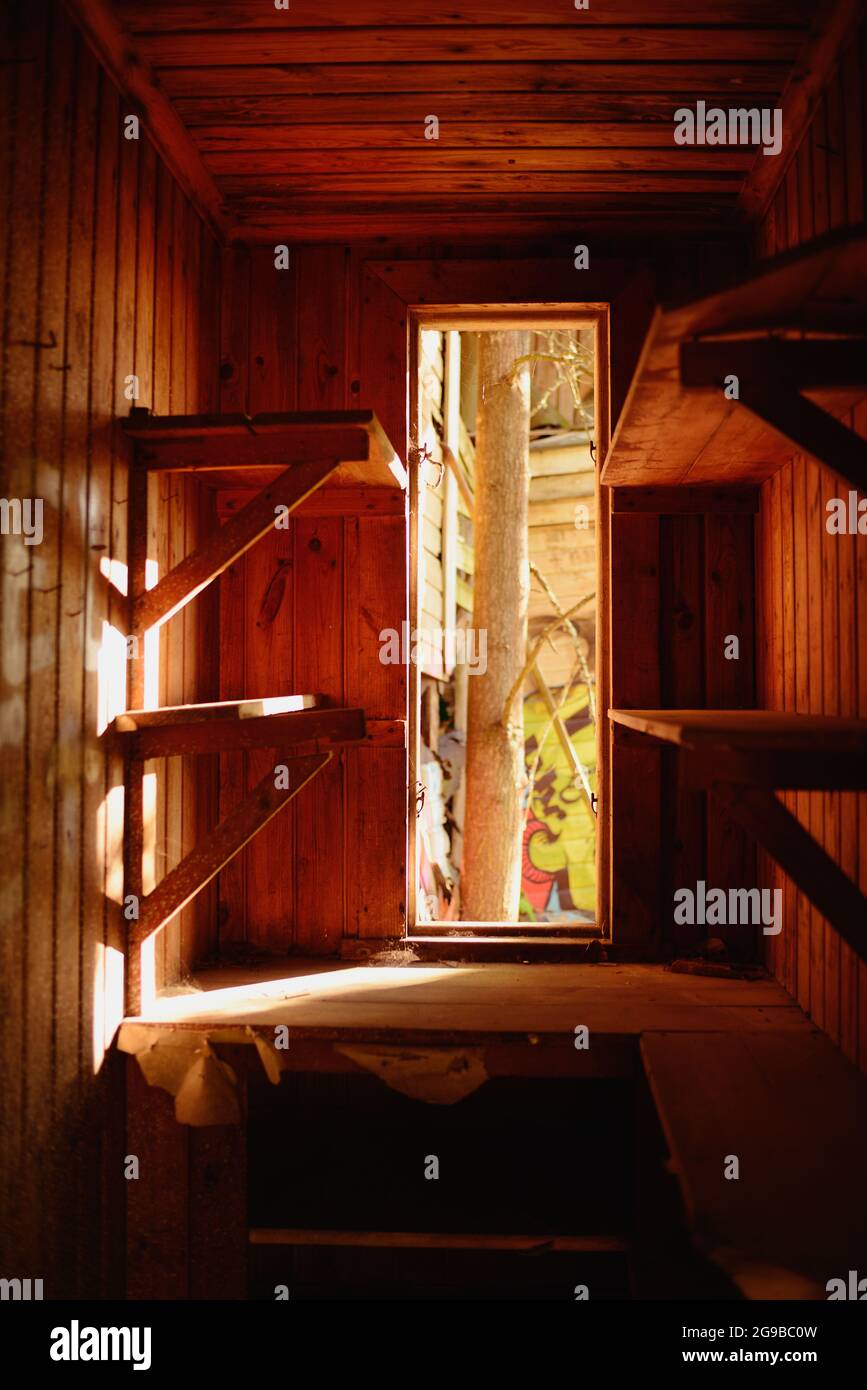 Die Inneneinrichtung eines kleinen Zimmers mit Holzverkleidungen, in dem Sonnenlicht einstrahlt Stockfoto