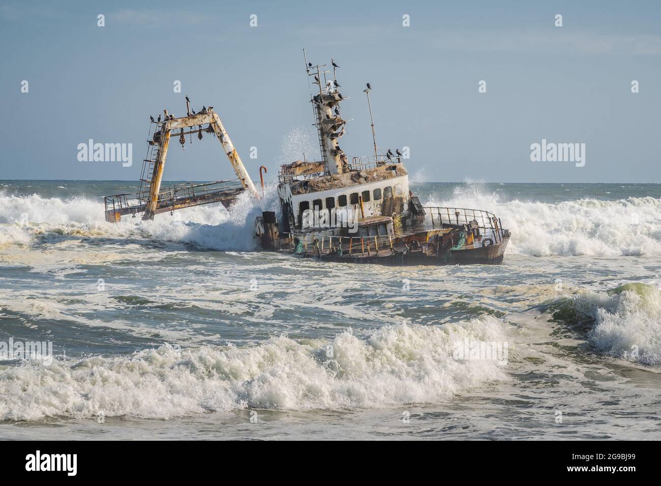 Wellen schlagen auf das Zeila Shipwreck an der Skeleton Coast in Namibia, Südwestafrika. Stockfoto