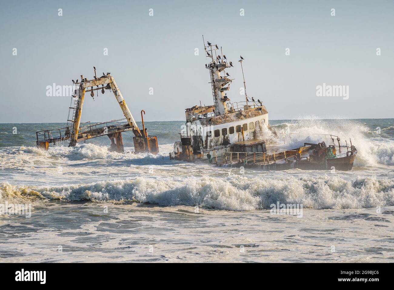 Wellen schlagen auf das Zeila Shipwreck an der Skeleton Coast in Namibia, Südwestafrika. Stockfoto